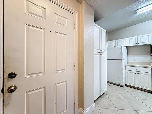 a kitchen with white cabinets and white appliances