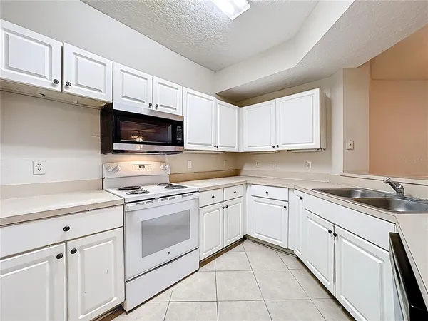 a kitchen with a sink stove top oven and cabinets