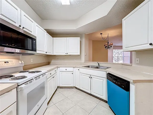 a kitchen with stainless steel appliances white cabinets white stove a microwave and a refrigerator