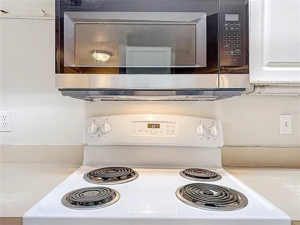 a kitchen with stainless steel appliances granite countertop a refrigerator and white cabinets