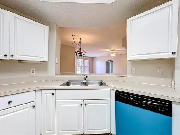 a view of a kitchen with white cabinets and white appliances