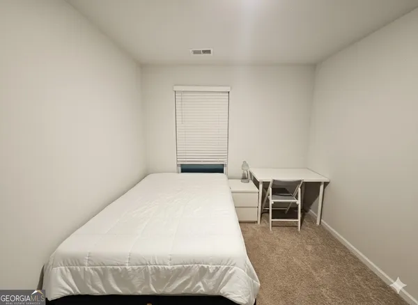 a bedroom with a bed and chair