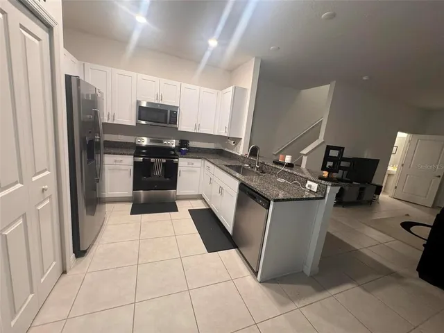 a kitchen with stainless steel appliances granite countertop a refrigerator and a stove