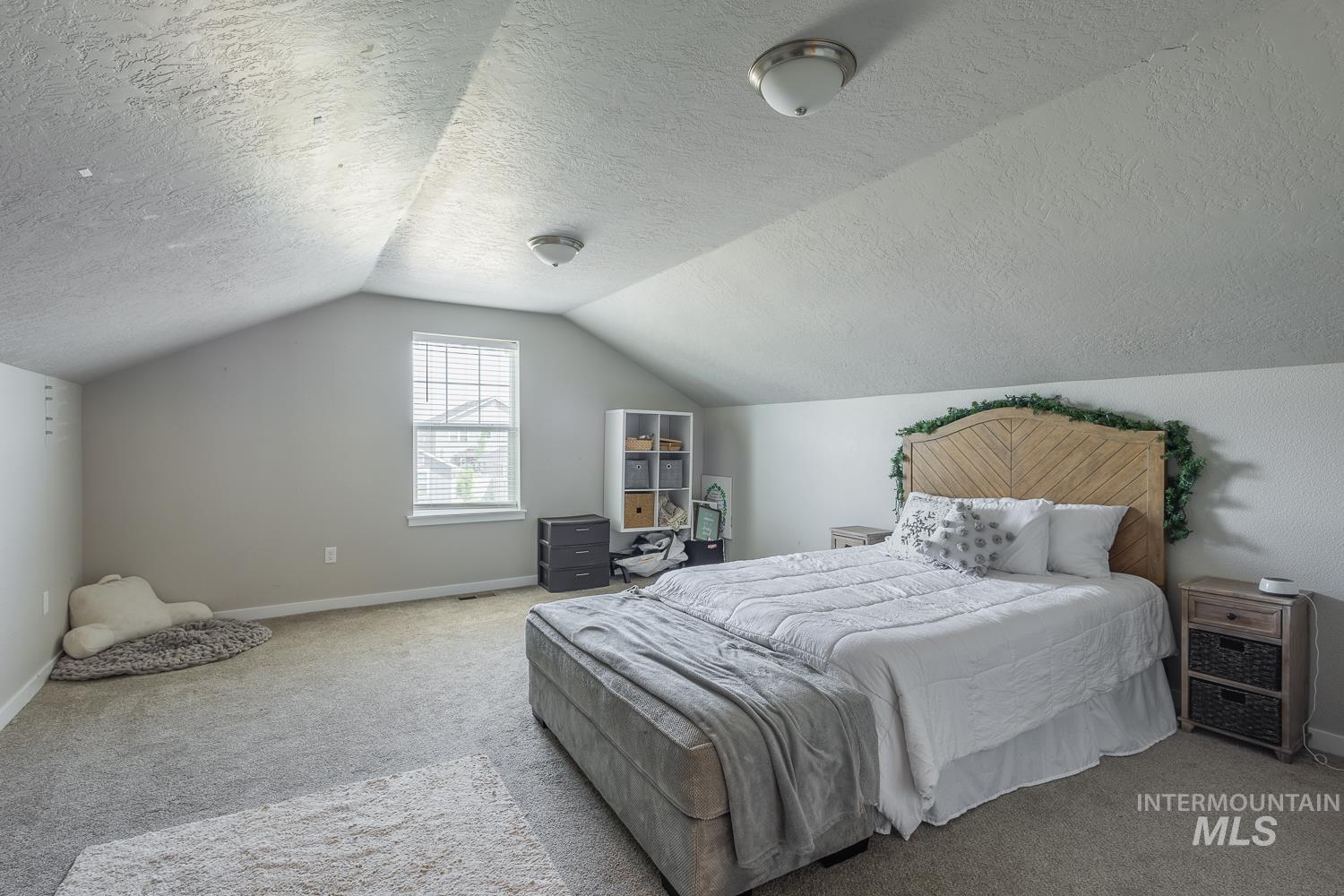 12623 Shadow Peak Street Caldwell, ID 83607 - Photo 44 of 50 Expansive room featuring vaulted ceilings and neutral-toned carpeting