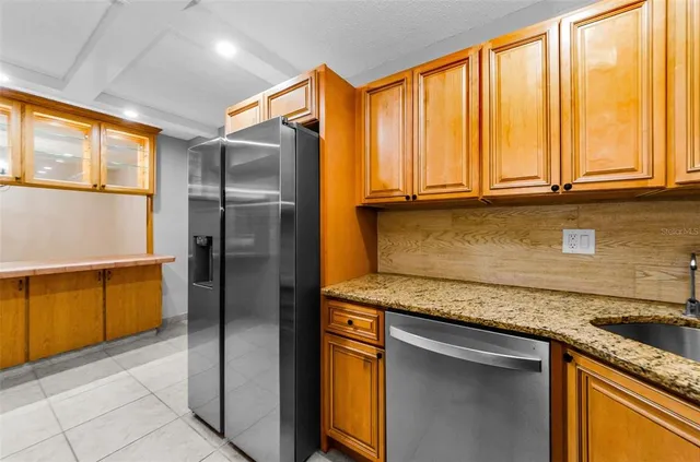 a kitchen with stainless steel appliances granite countertop a refrigerator and a sink