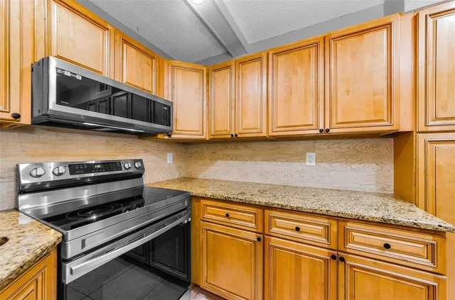 a kitchen with stainless steel appliances granite countertop a stove a microwave and cabinets