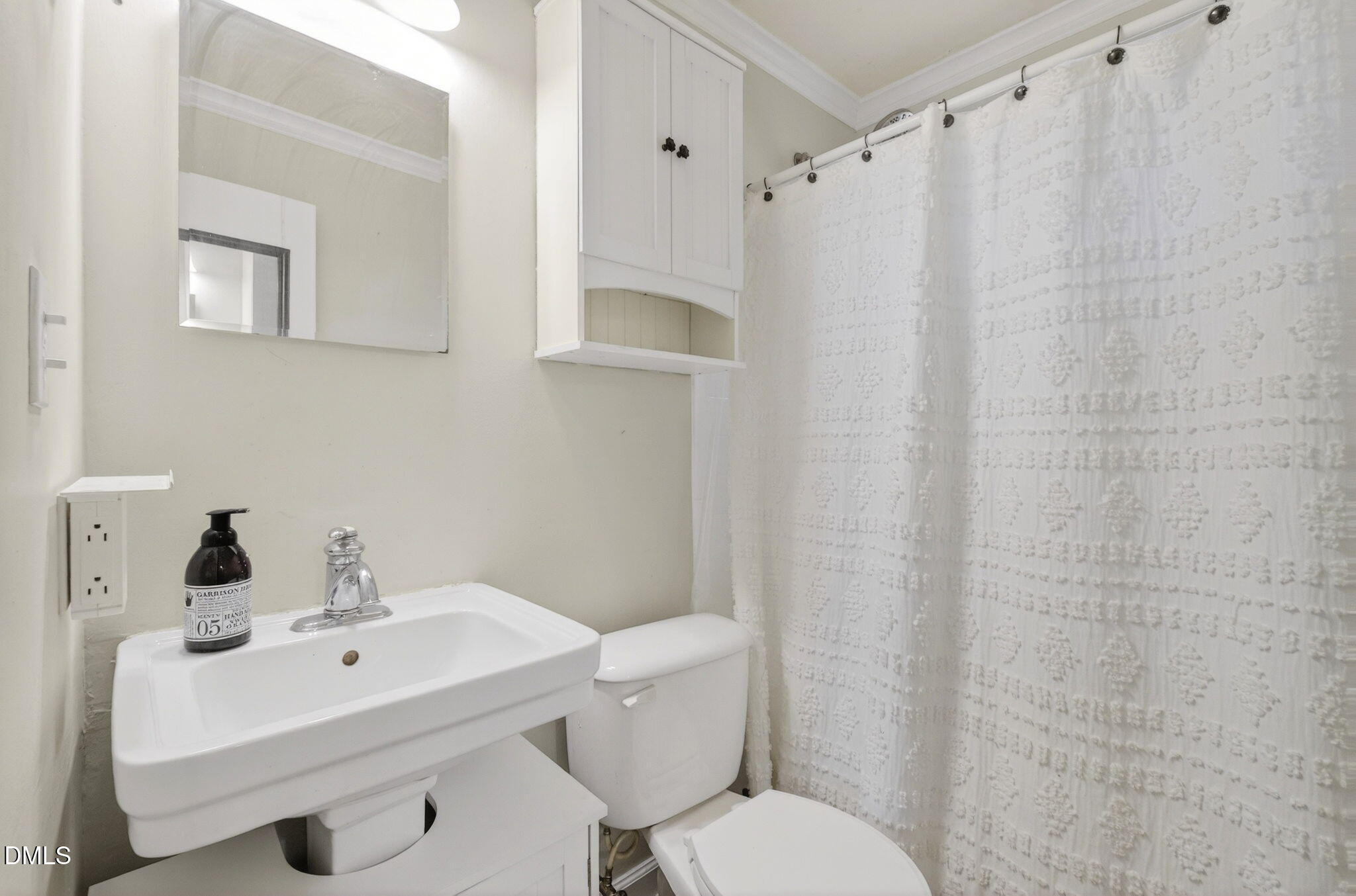 827 Daniels Street, Unit D Raleigh, NC 27605 - Photo 9 of 15 a bathroom with a sink a toilet and shower curtain