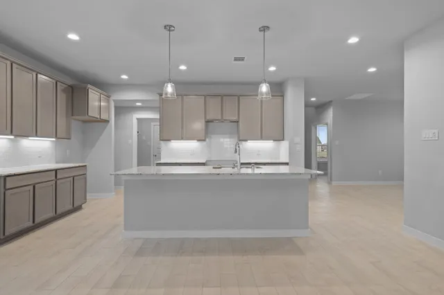 a large kitchen with kitchen island a sink stainless steel appliances and a cabinets