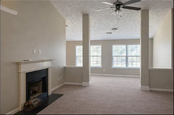 a view of an empty room with a fireplace and a window
