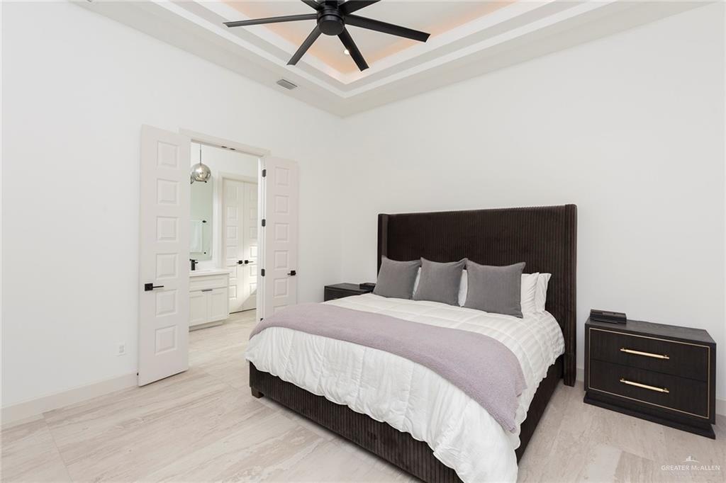 1505 Mount Street Mission, TX 78572 - Photo 21 of 25 Bedroom featuring ceiling fan, ensuite bath, and a raised ceiling