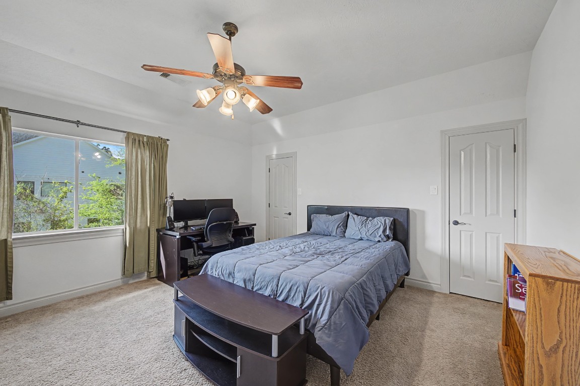 27223 Blue Cedar Lane Spring, TX 77386 - Photo 42 of 50 a bedroom with a bed and a chandelier