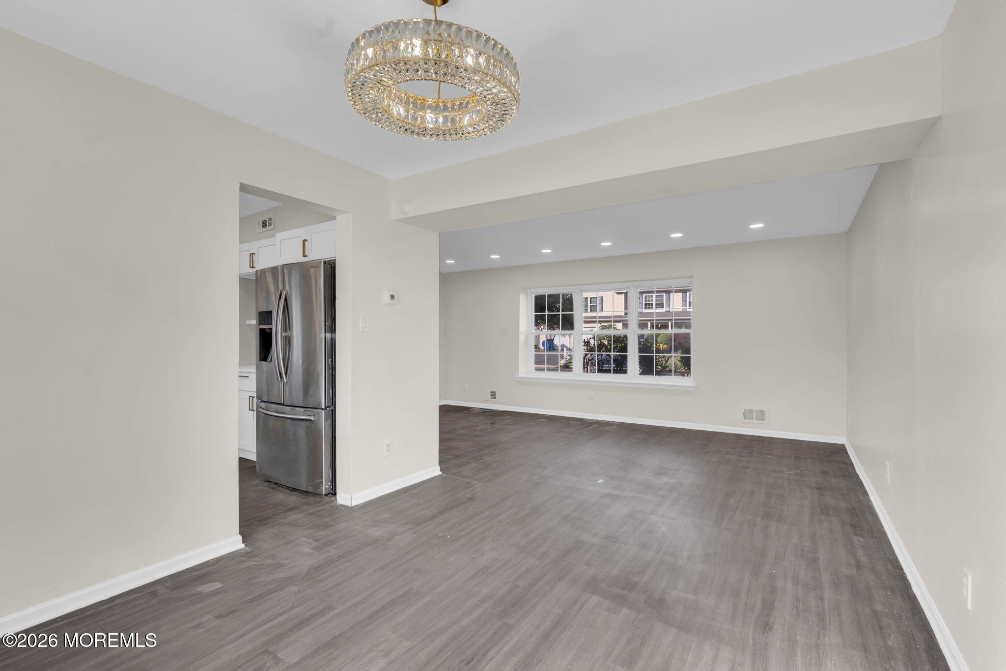 45 Peachstone Road Howell, NJ 07731 - Photo 15 of 54 an empty room with wooden floor and a kitchen space