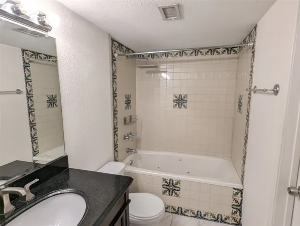 a bathroom with a granite countertop sink toilet bathtub and shower