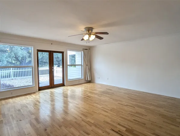 a view of empty room with a ceiling fan and window