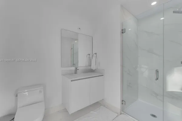 a bathroom with a granite countertop sink a toilet and shower