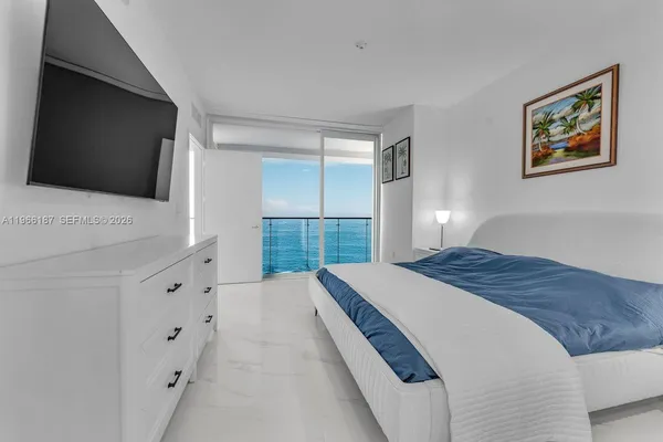 a spacious bedroom with a large bed and a flat screen tv