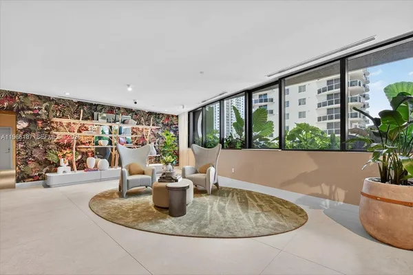 a living room with furniture potted plant and a large window
