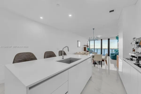 a living room with two couches and kitchen view