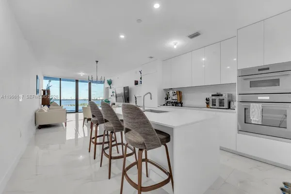 a kitchen with stainless steel appliances kitchen island granite countertop a refrigerator and microwave
