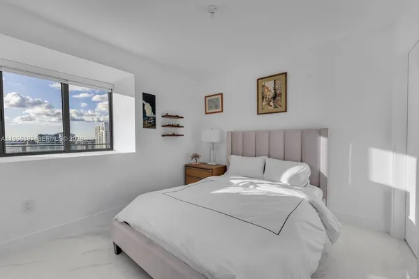 a bed sitting in a bedroom next to a window