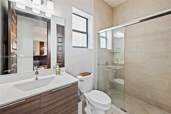 a bathroom with a sink toilet vanity and shower