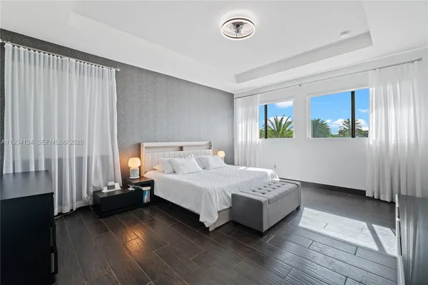 a spacious bedroom with a bed and wooden floor