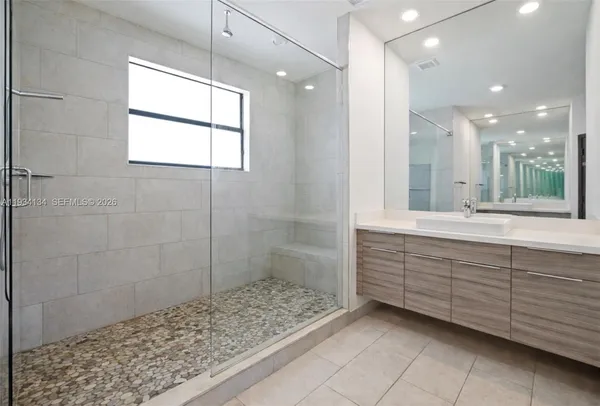 a bathroom with a sink a toilet a large mirror and shower