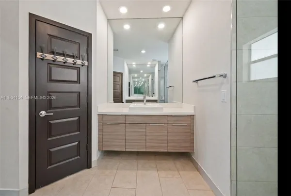 a bathroom with a sink a mirror and shower