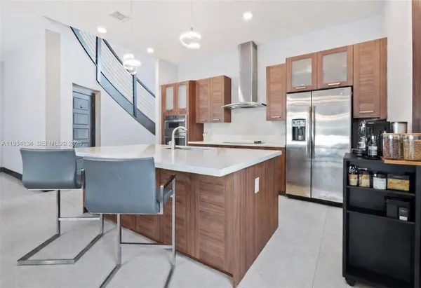 a kitchen with stainless steel appliances granite countertop a refrigerator a stove and a sink