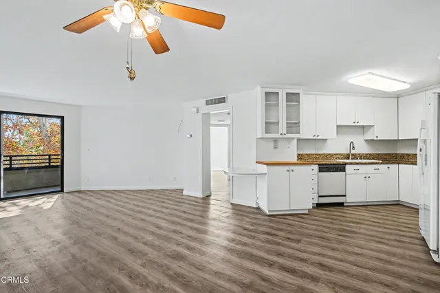 a kitchen with a refrigerator and white cabinets