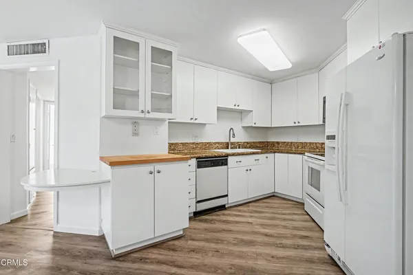 a kitchen with granite countertop white cabinets and white appliances