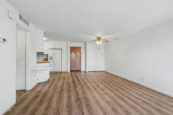 a view of empty room with wooden floor