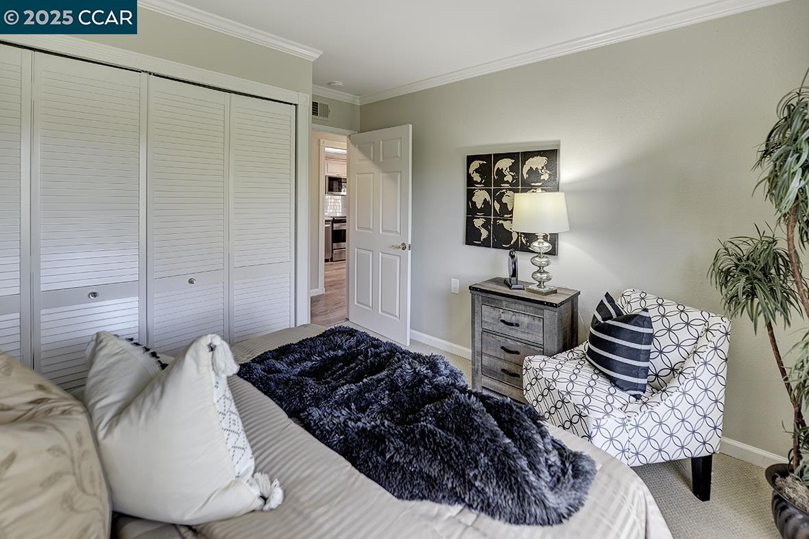 2424 Tice Creek Drive, Unit 2 Walnut Creek, CA 94595 - Photo 24 of 54 a bedroom with a bed and ceiling fan