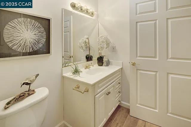 a bathroom with a granite countertop toilet a sink and a mirror