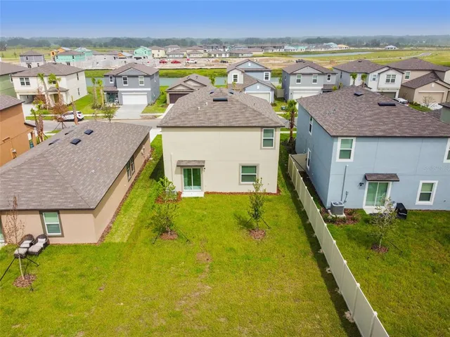 an aerial view of residential houses with outdoor space and swimming pool