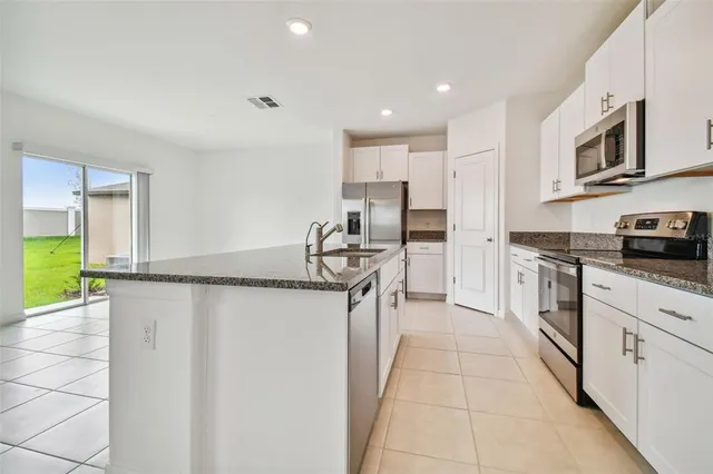 a kitchen with stainless steel appliances a refrigerator sink and microwave