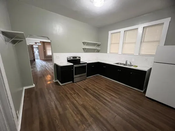 a kitchen with stainless steel appliances a sink a stove a refrigerator and cabinets