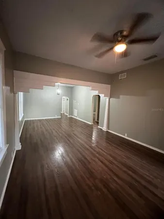 a view of empty room with wooden floor
