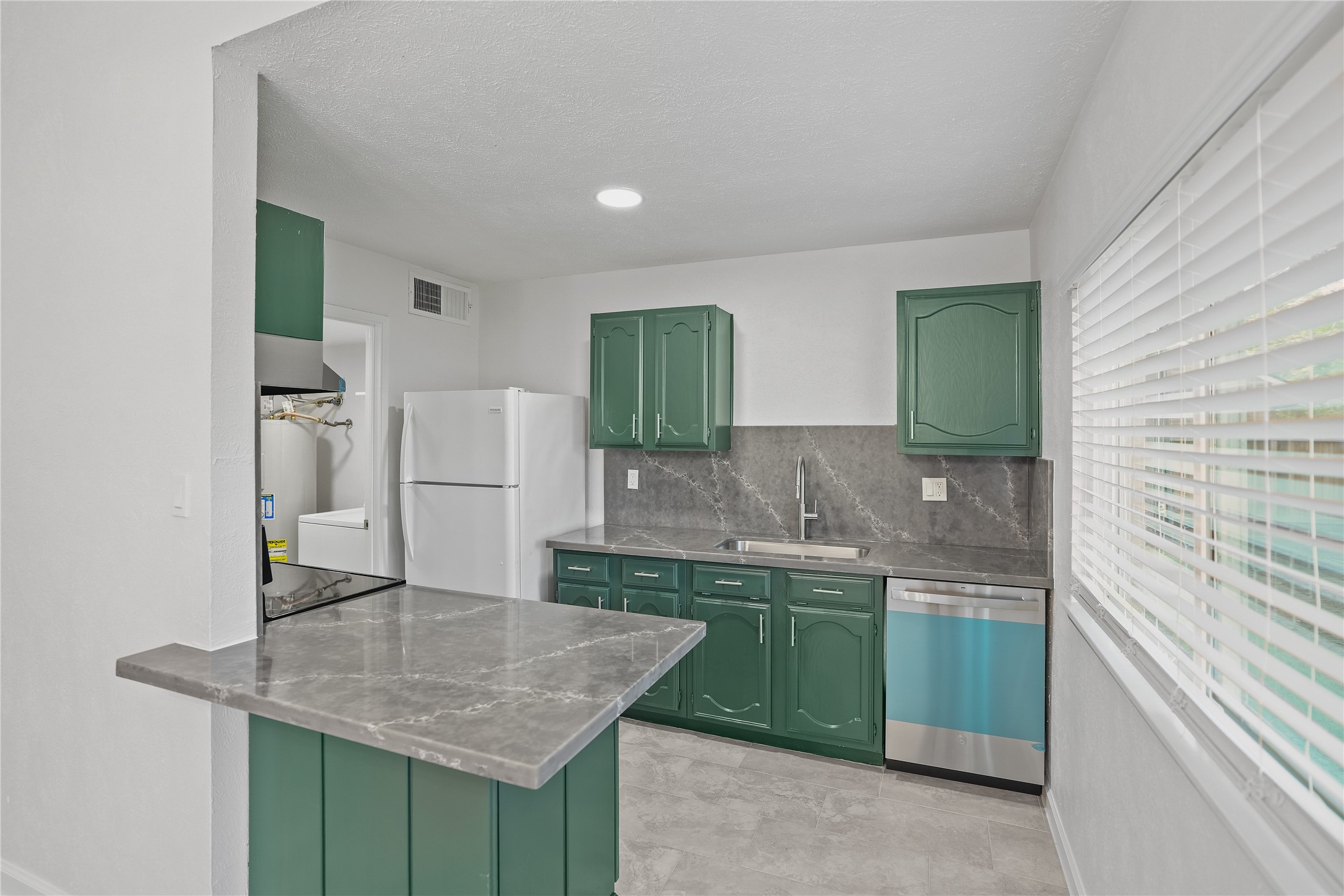 6610 Blue Ridge Drive Richmond, TX 77469 - Photo 9 of 24 Kitchen comes fully equipped with a refrigerator, range, and dishwasher, making this home truly move-in ready. Convenient adjacent utility room also includes a washer and dryer for added value.
