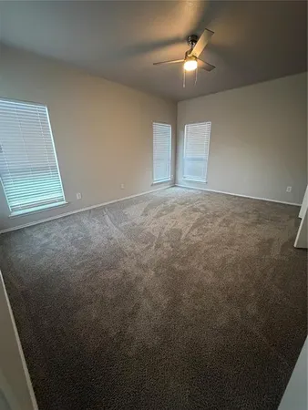 a view of an empty room and chandelier fan