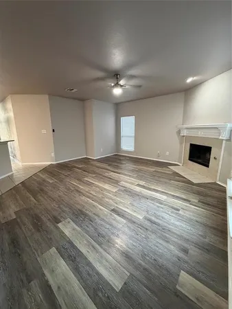 a view of an empty room with a fireplace and a window