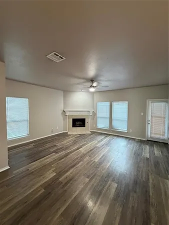 a view of empty room with wooden floor and fireplace