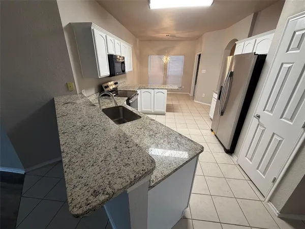 a kitchen with granite countertop a sink and a stove top oven