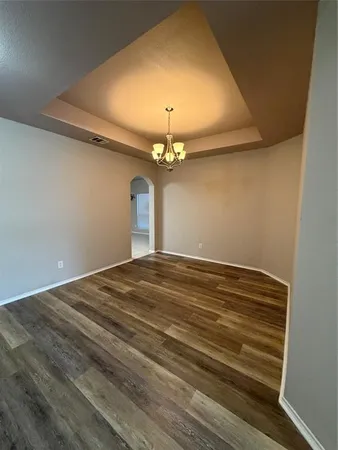 a view of a livingroom with a chandelier fan and wooden floor
