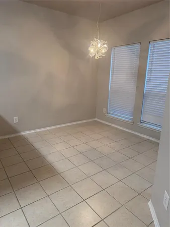 a view of an empty room with a chandelier fan