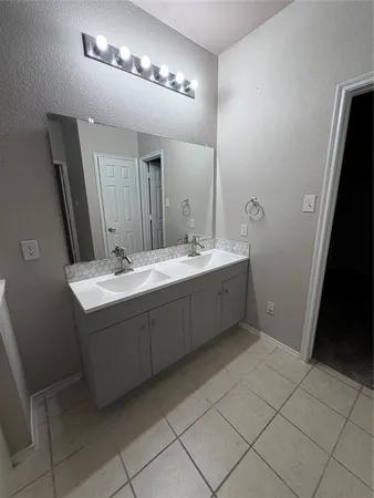 a bathroom with a double vanity sink and a mirror