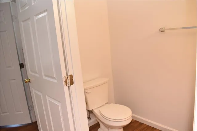 a white toilet sitting next to a shower