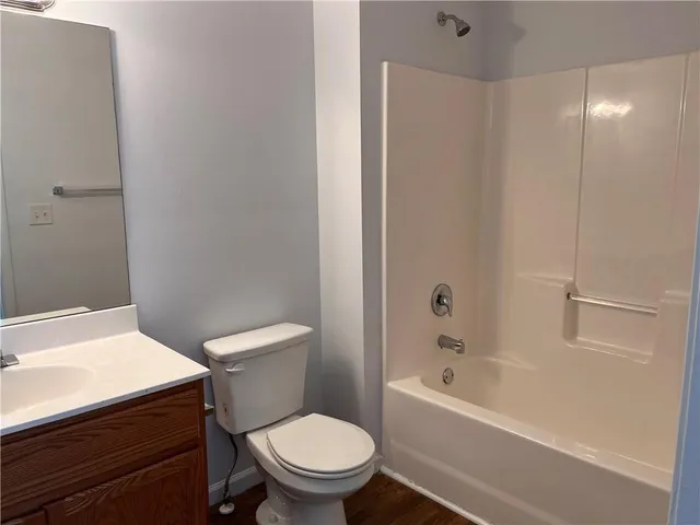 a white toilet sitting next to a bath tub