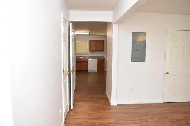 a view of a hallway with wooden floor and a bathroom
