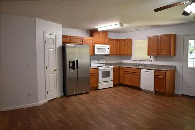 a kitchen with stainless steel appliances granite countertop a stove top oven a refrigerator and a sink